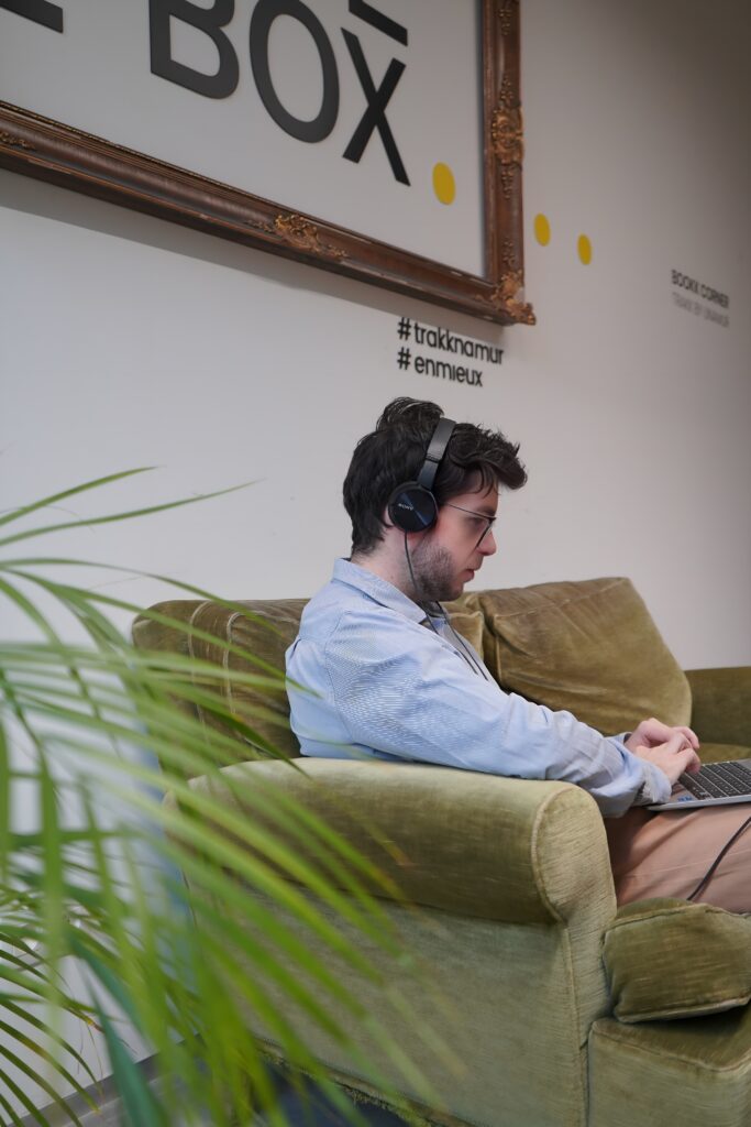 Assistant à distance travaillant depuis un canapé dans un espace moderne.